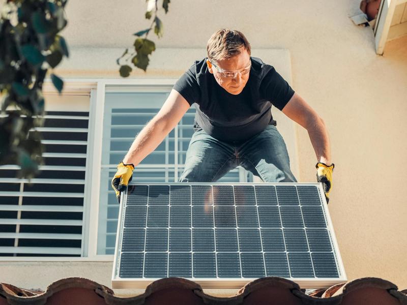 Solar installer working on rooftop panels